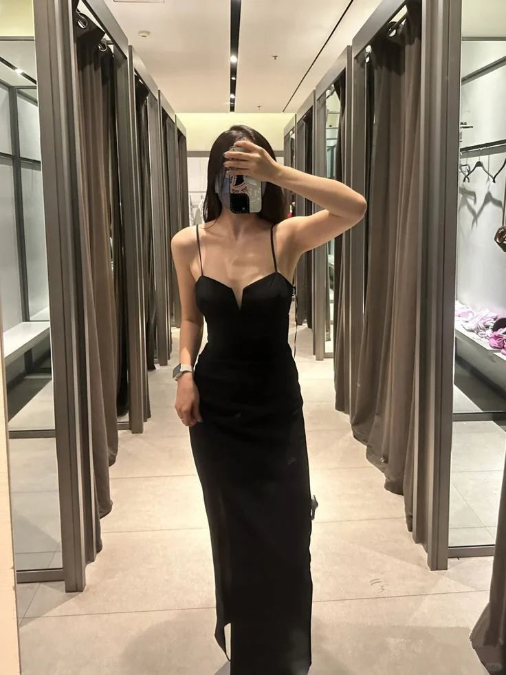 Woman wearing an elegant black sleeveless formal prom dress.
