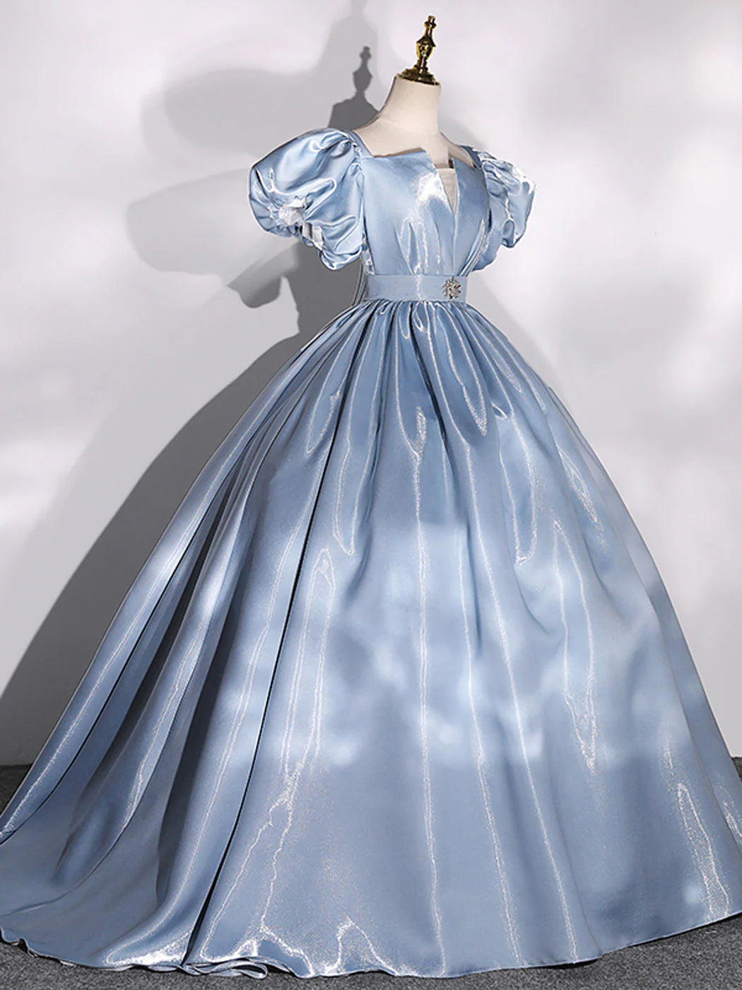 Blue long ball gown with puff sleeves, side view.