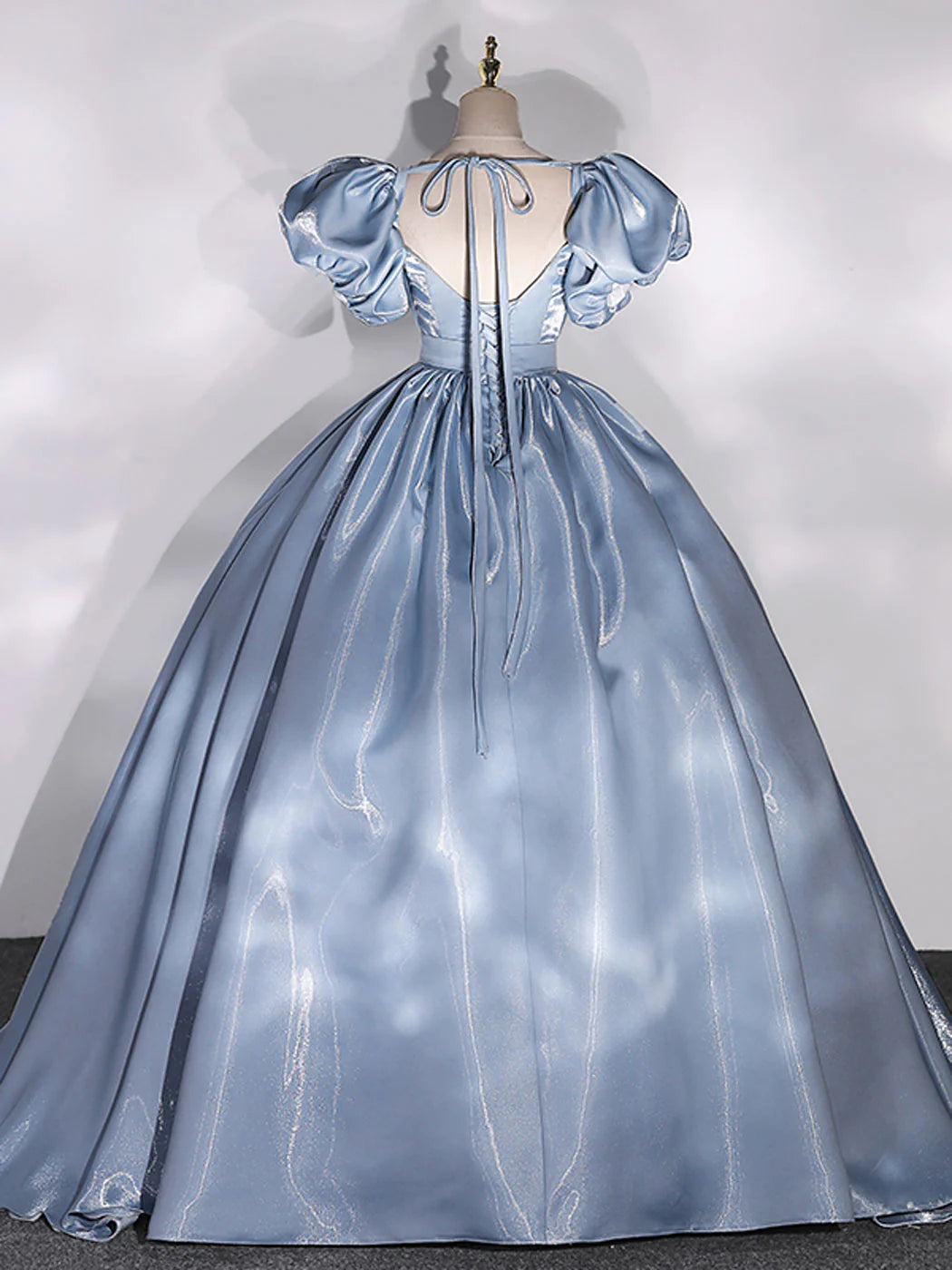 Back view of a stunning blue ball gown with puff sleeves.