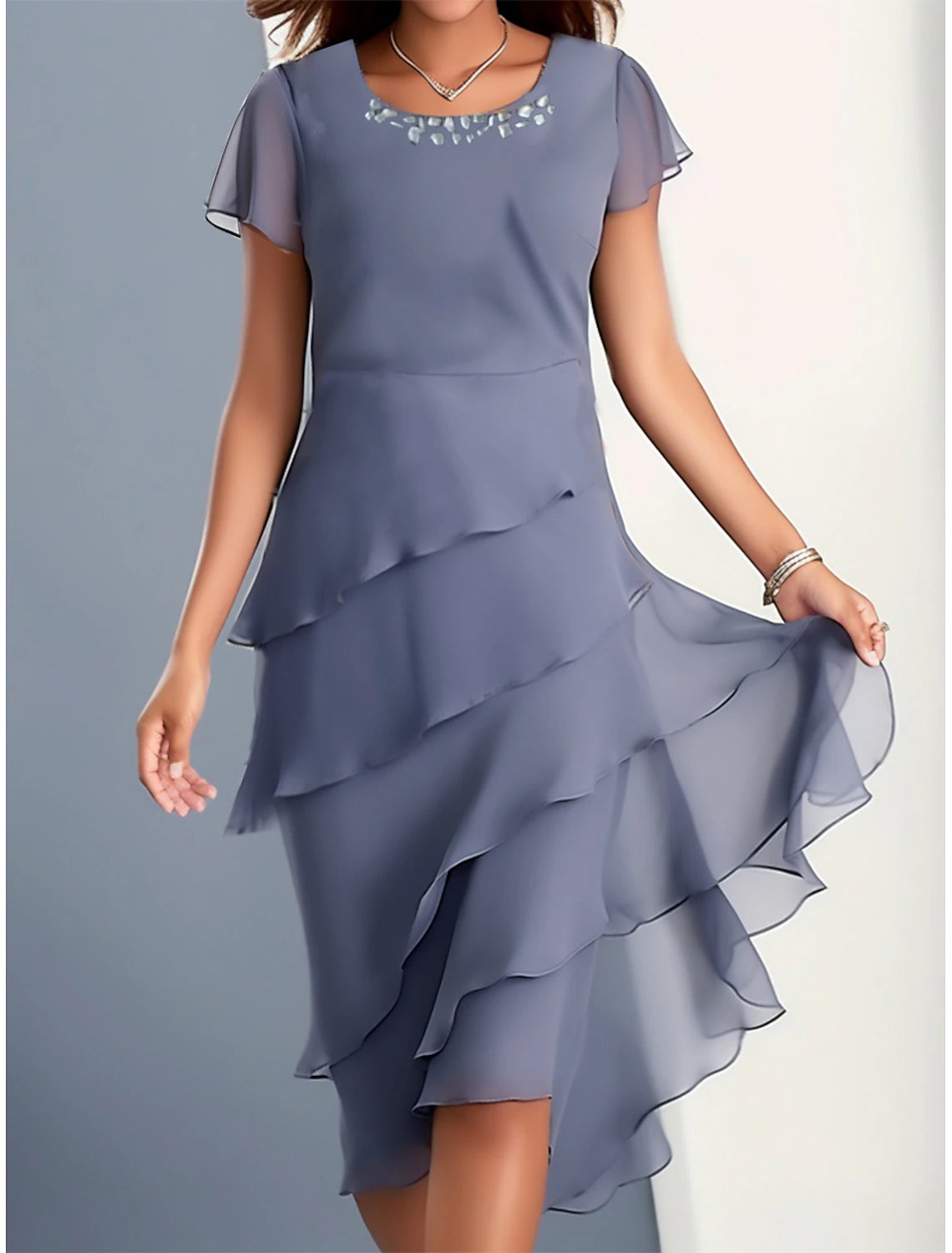 Woman wearing an elegant blue ruffle short sleeve crew neck party dress.