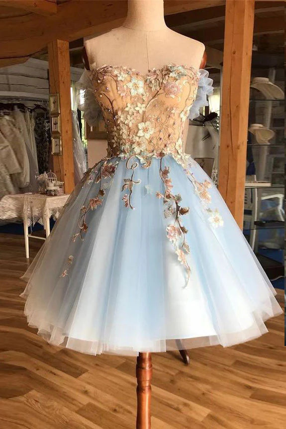 Model wearing a short blue tulle lace A-line prom dress with delicate appliques.