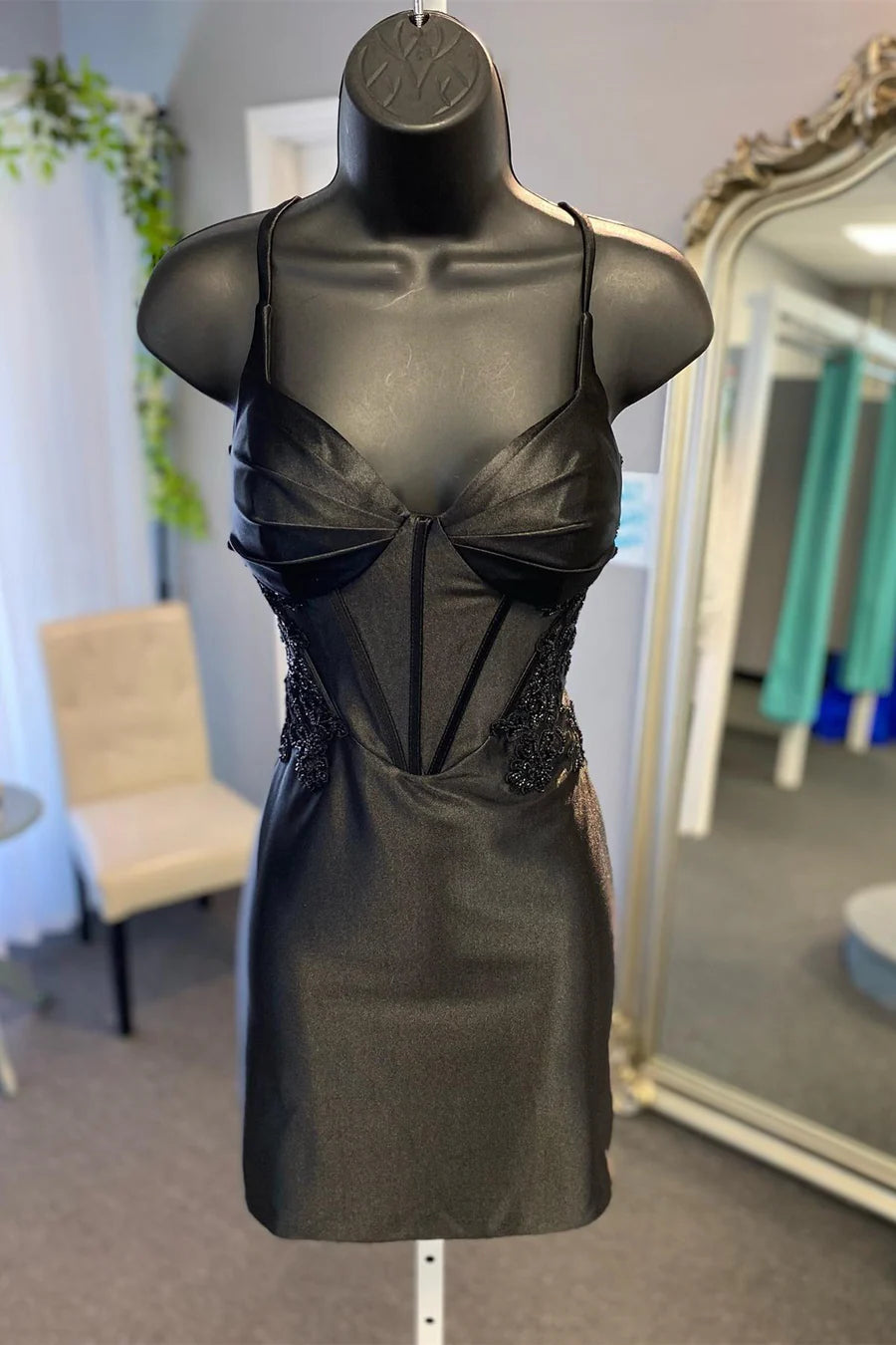 Back view of a peacock blue short party dress with delicate applique details.