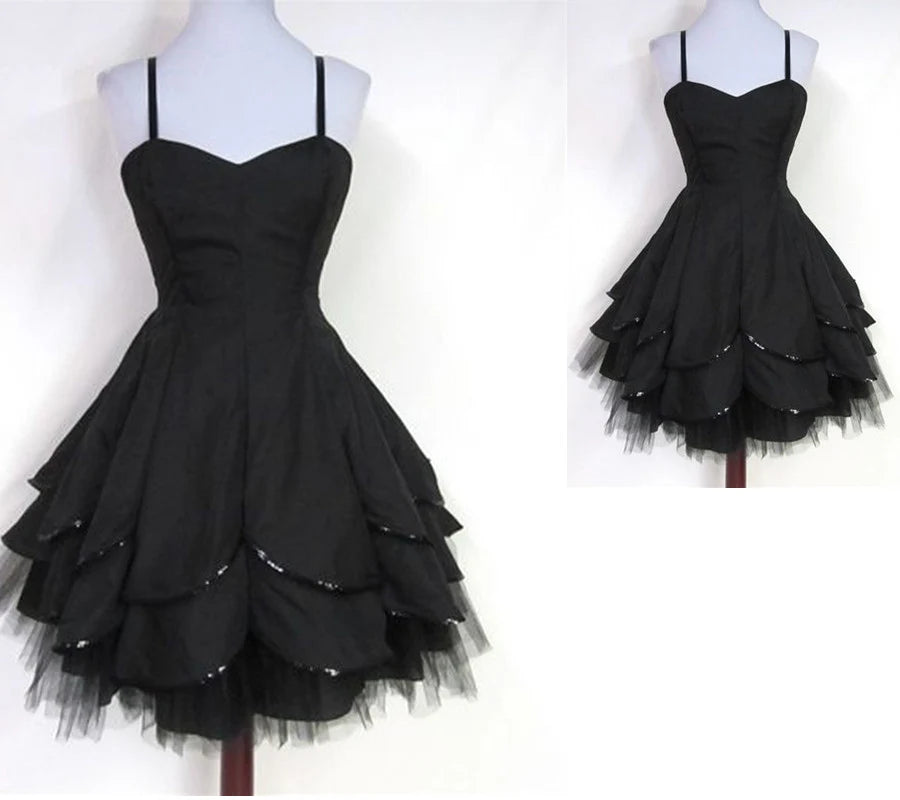 Woman wearing an elegant champagne A-line tea-length homecoming dress with appliques and spaghetti straps.