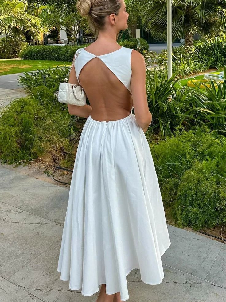 Model posing in a white O-neck sleeveless long dress.