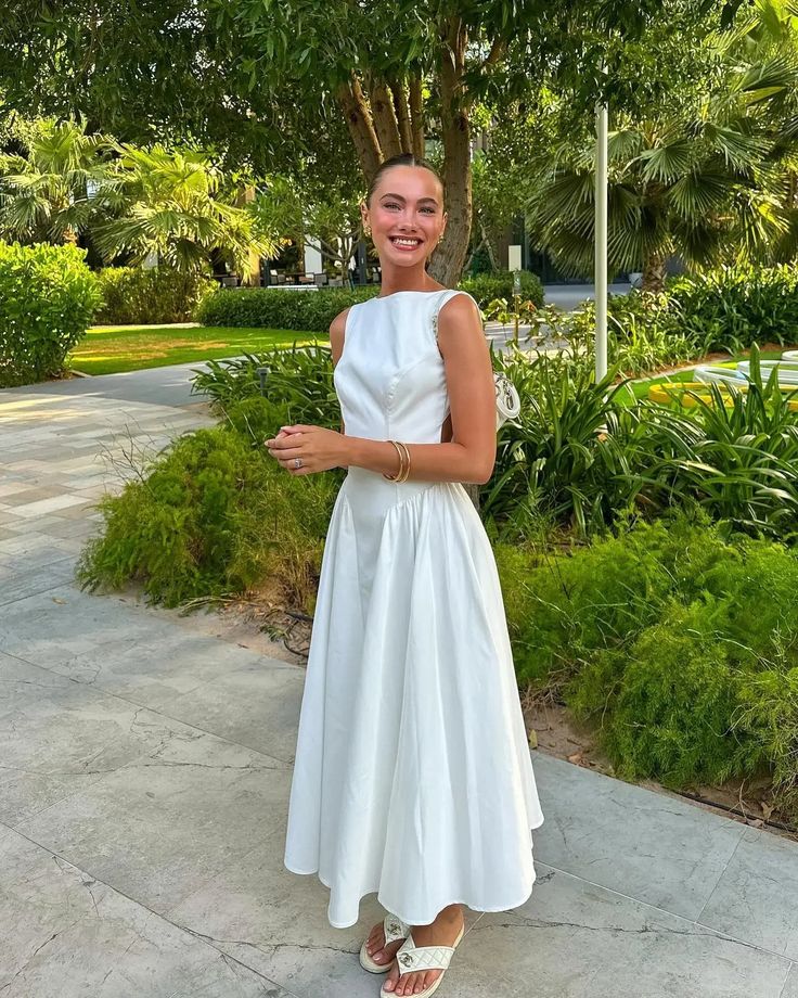 Full length view of a woman in a white long formal dress.