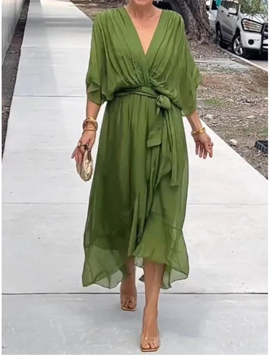 Woman wearing an elegant white chiffon ruffle V-neck maxi dress with 3/4 sleeves and lace-up detail.