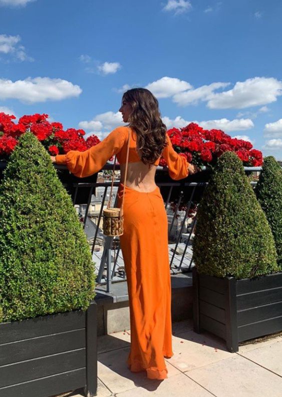 Model showcasing a classic fit orange long sleeve formal gown.