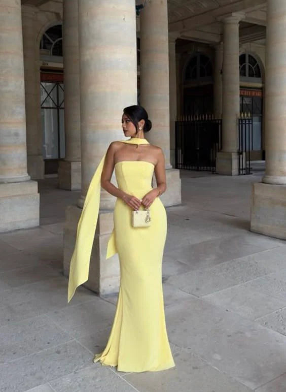 Woman wearing a dark, elegant off-shoulder strapless mermaid evening gown.