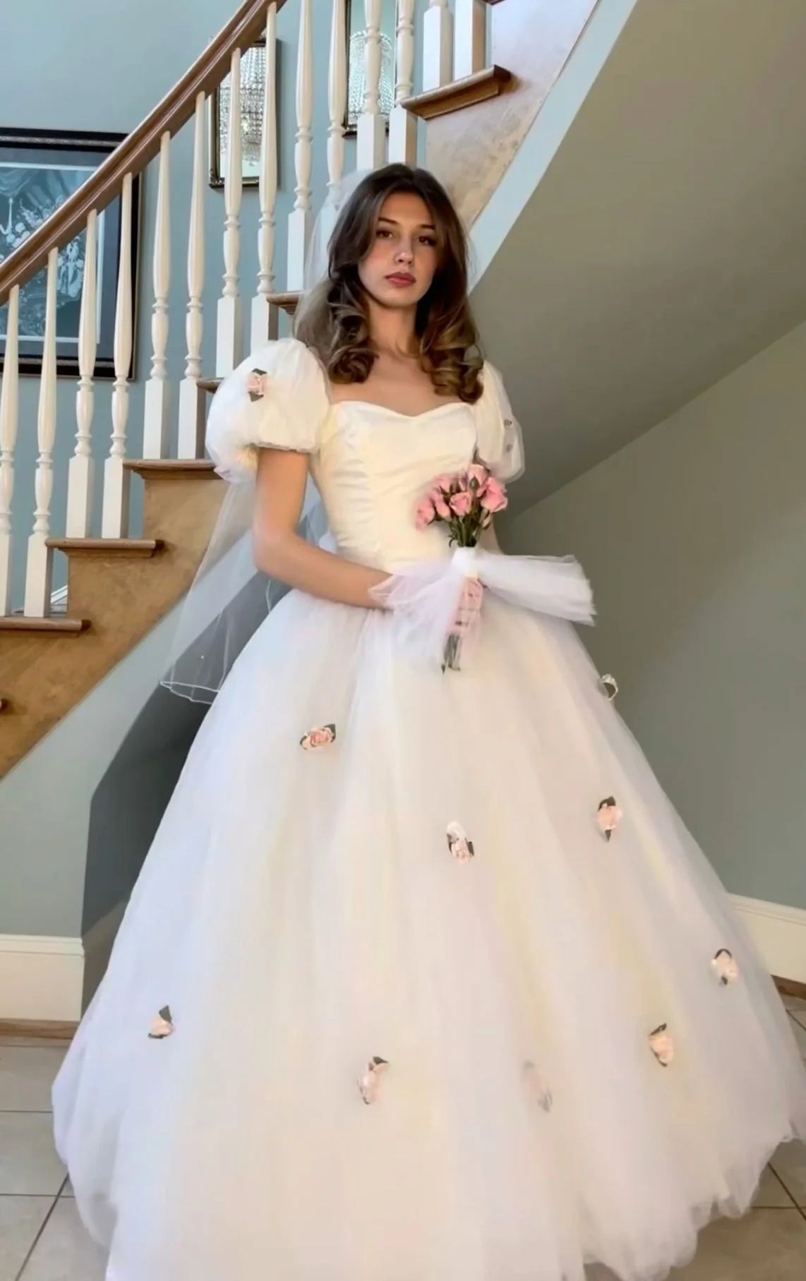 Full-length view of a woman in an elegant white tulle 1980s princess bridal gown.