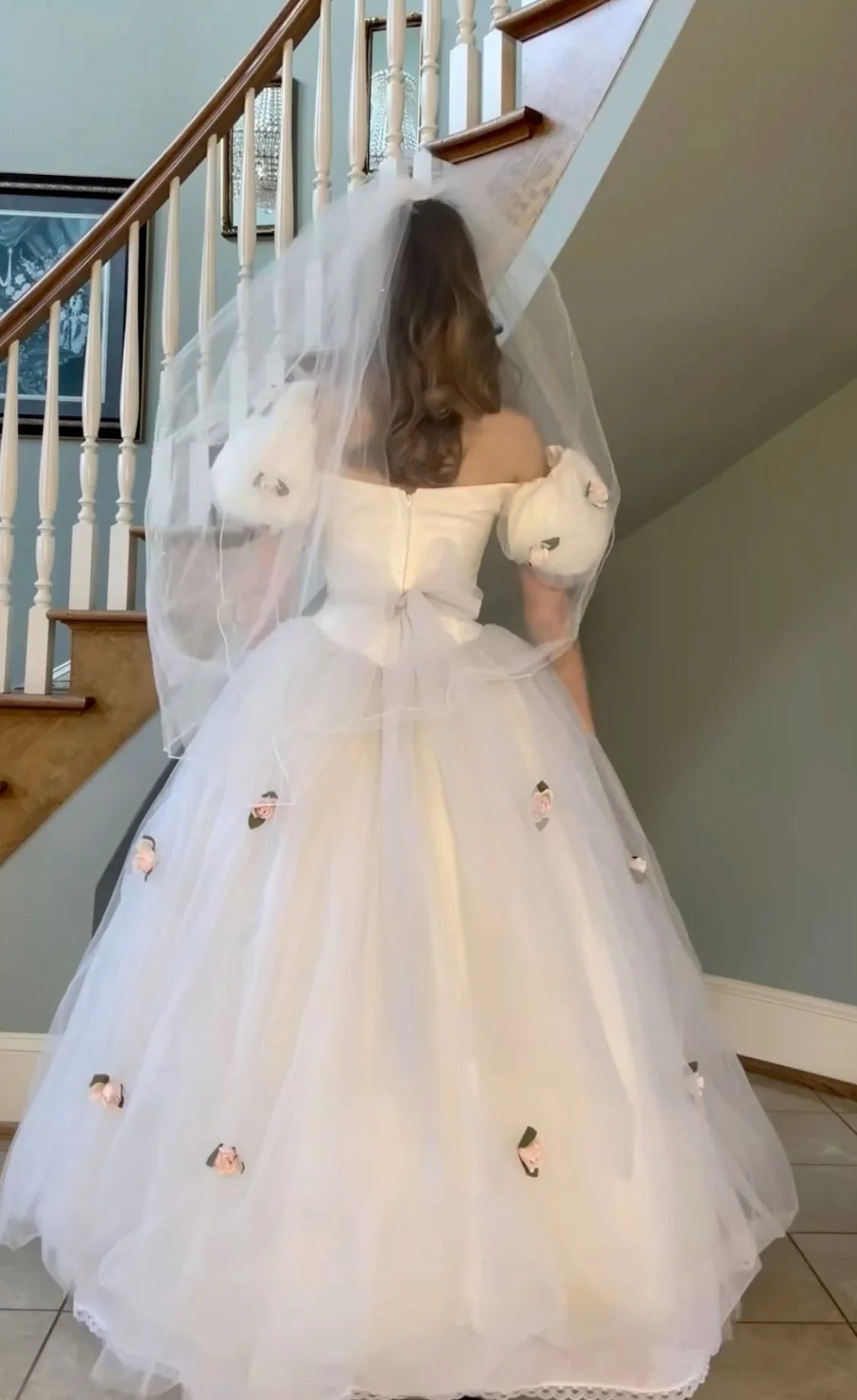 Side view of a woman showcasing the classic fit of a white tulle wedding dress.