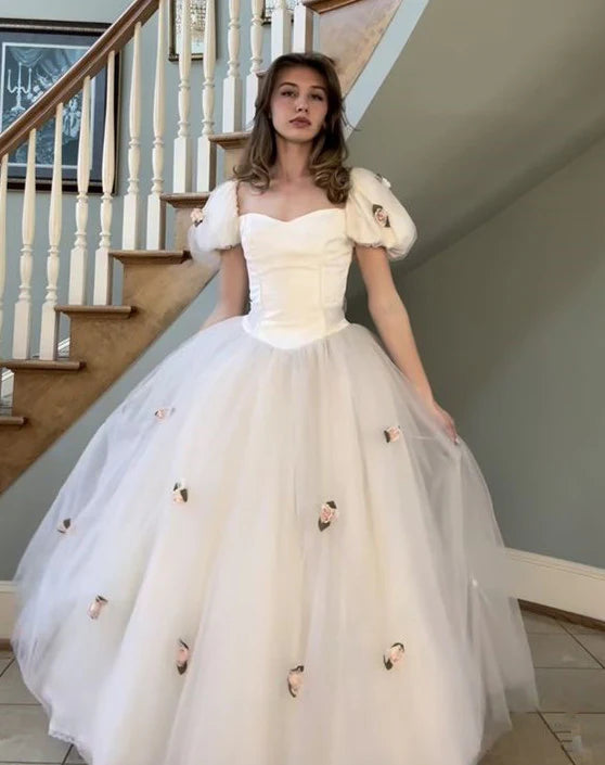 Close-up of the bodice and flowing skirt detail of a white tulle bridal gown.