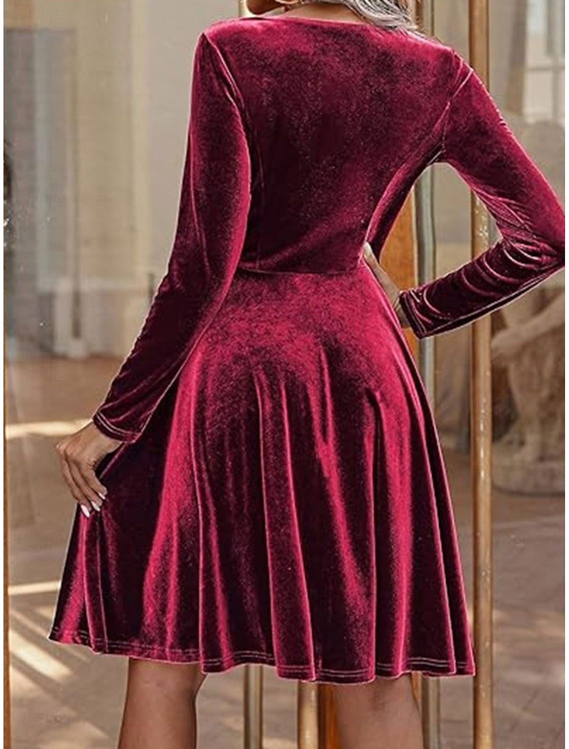 Side view of woman in black long-sleeve crew neck party dress.