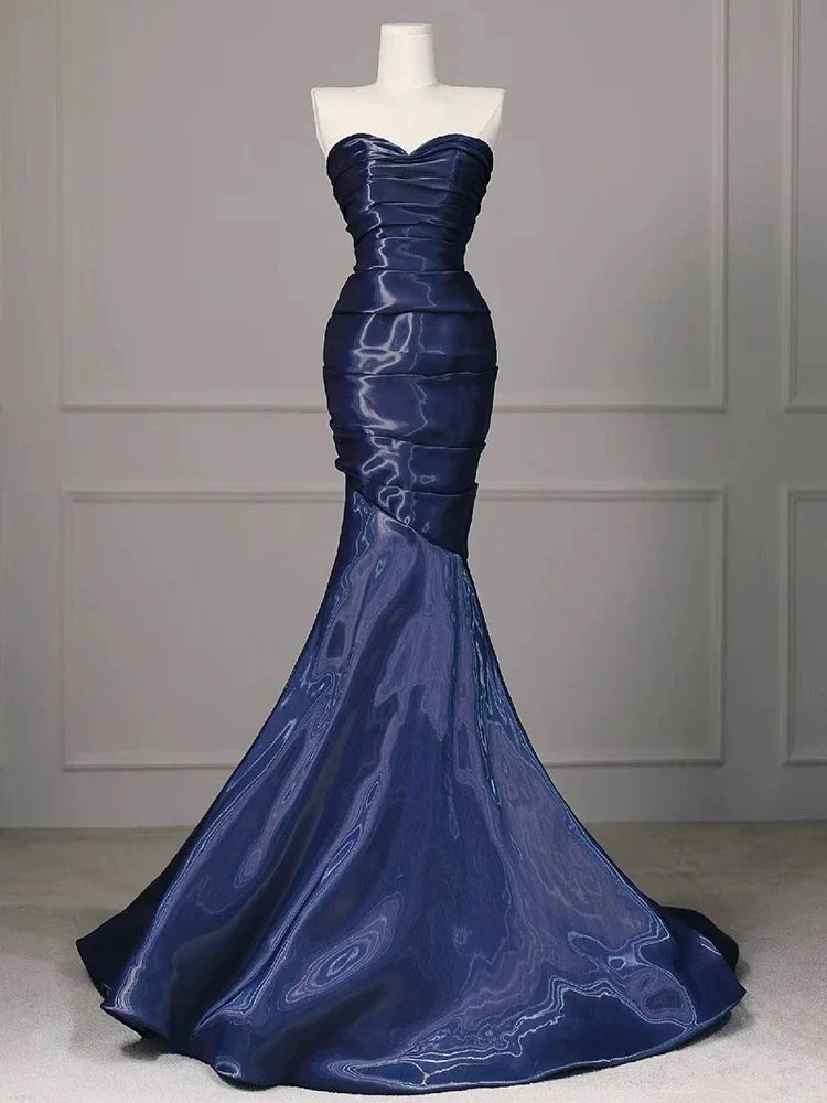 Side view of the dark blue water satin mermaid gown.
