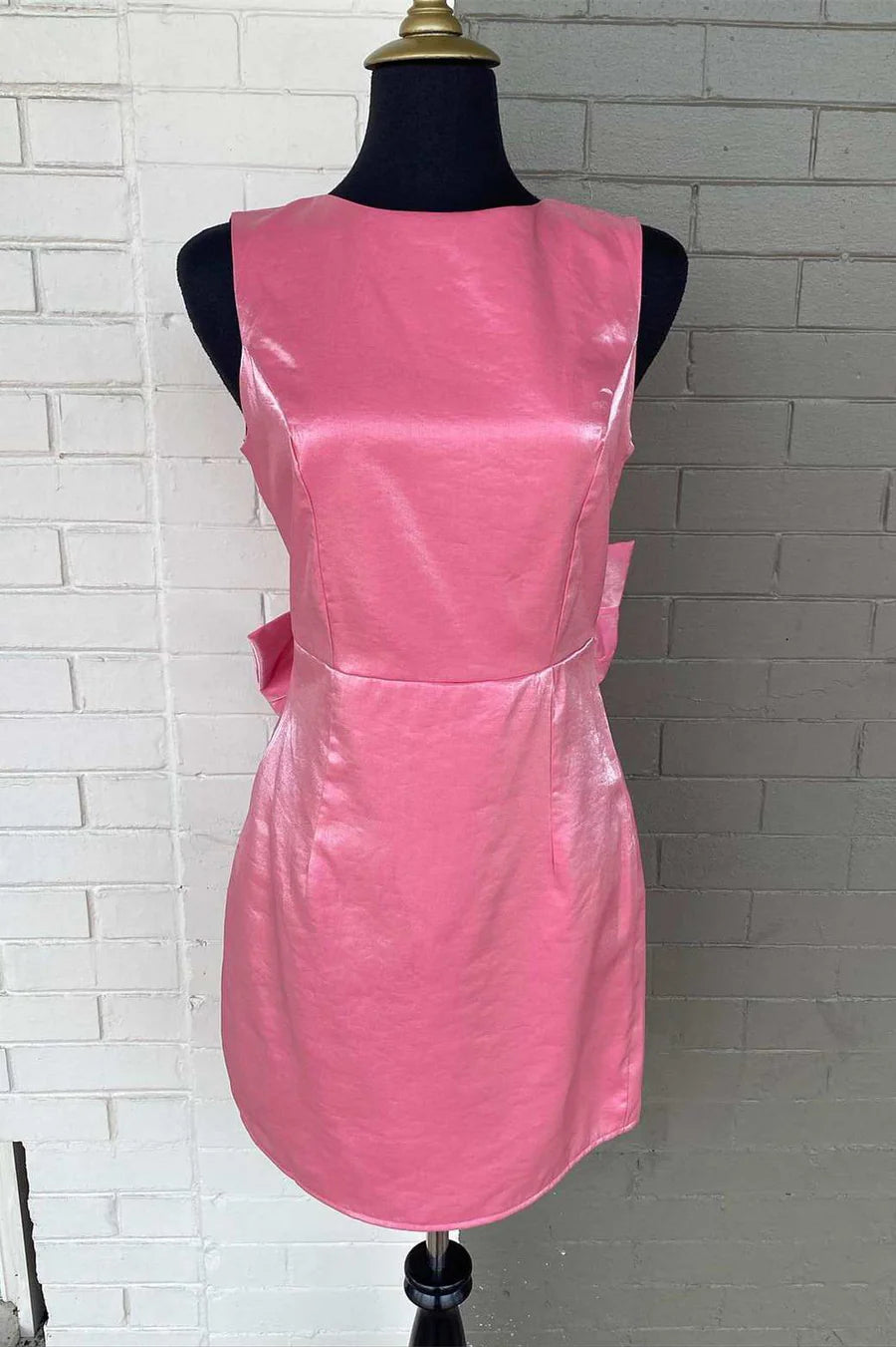 Front view of an elegant sleeveless short party dress with a crew neck and fitted waist.