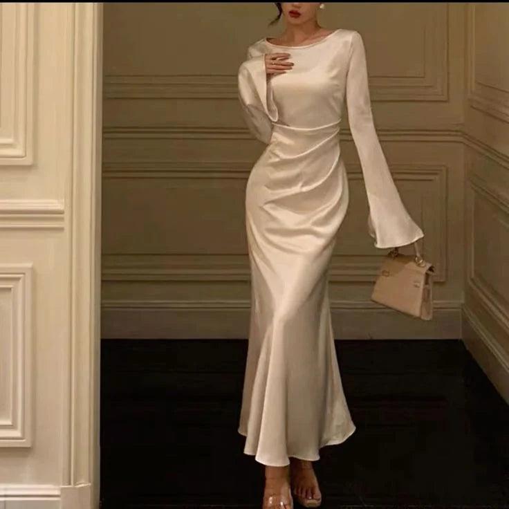 Full view of a long white bridal gown with graceful flare sleeves.