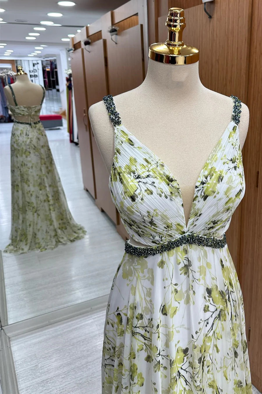 Close-up of the beaded V-neckline and floral pattern on the chiffon maxi dress.