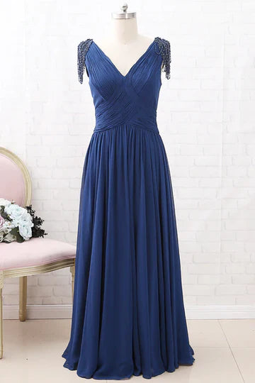 Woman wearing an elegant navy blue chiffon V-neck long mother of the bride dress.