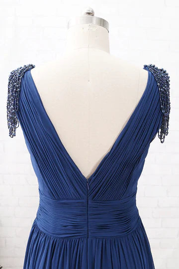 Close-up of the V-neckline and delicate tassel sleeves on the navy blue dress.
