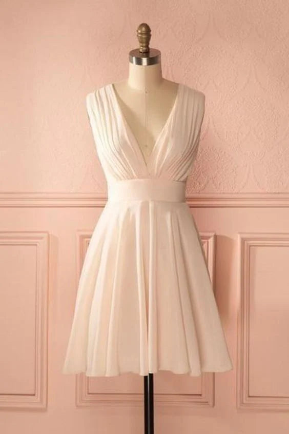 Woman wearing a white deep V-neck sleeveless pleated chiffon maxi dress.