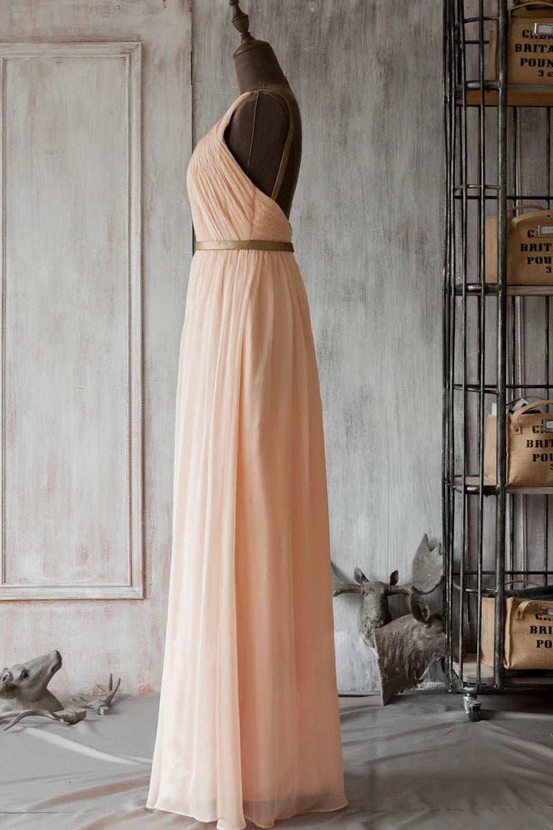 Back view of a model in a flowing pink chiffon bridesmaid dress, highlighting the backless detail.