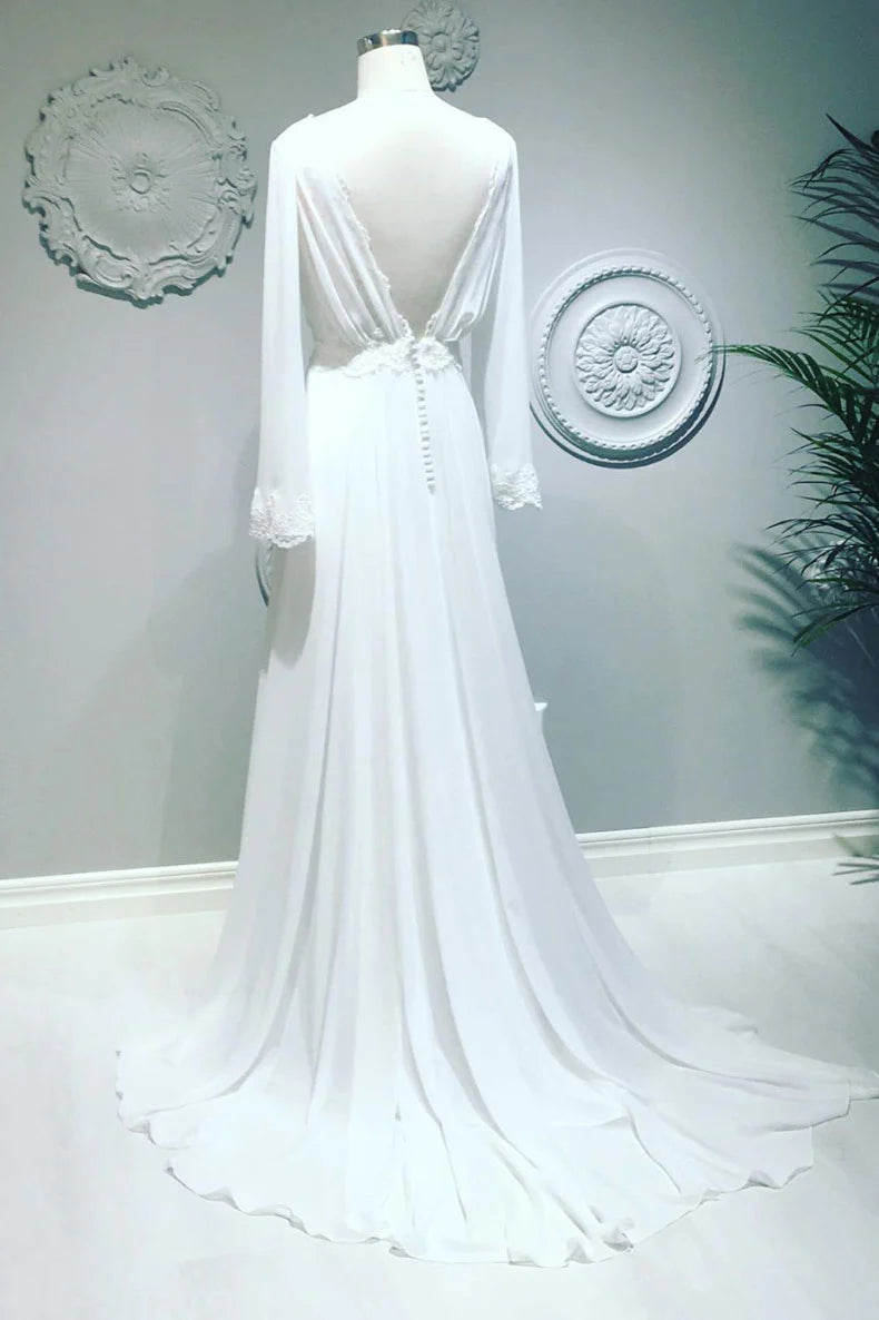 Model posing in a graceful white chiffon V-neck evening gown.