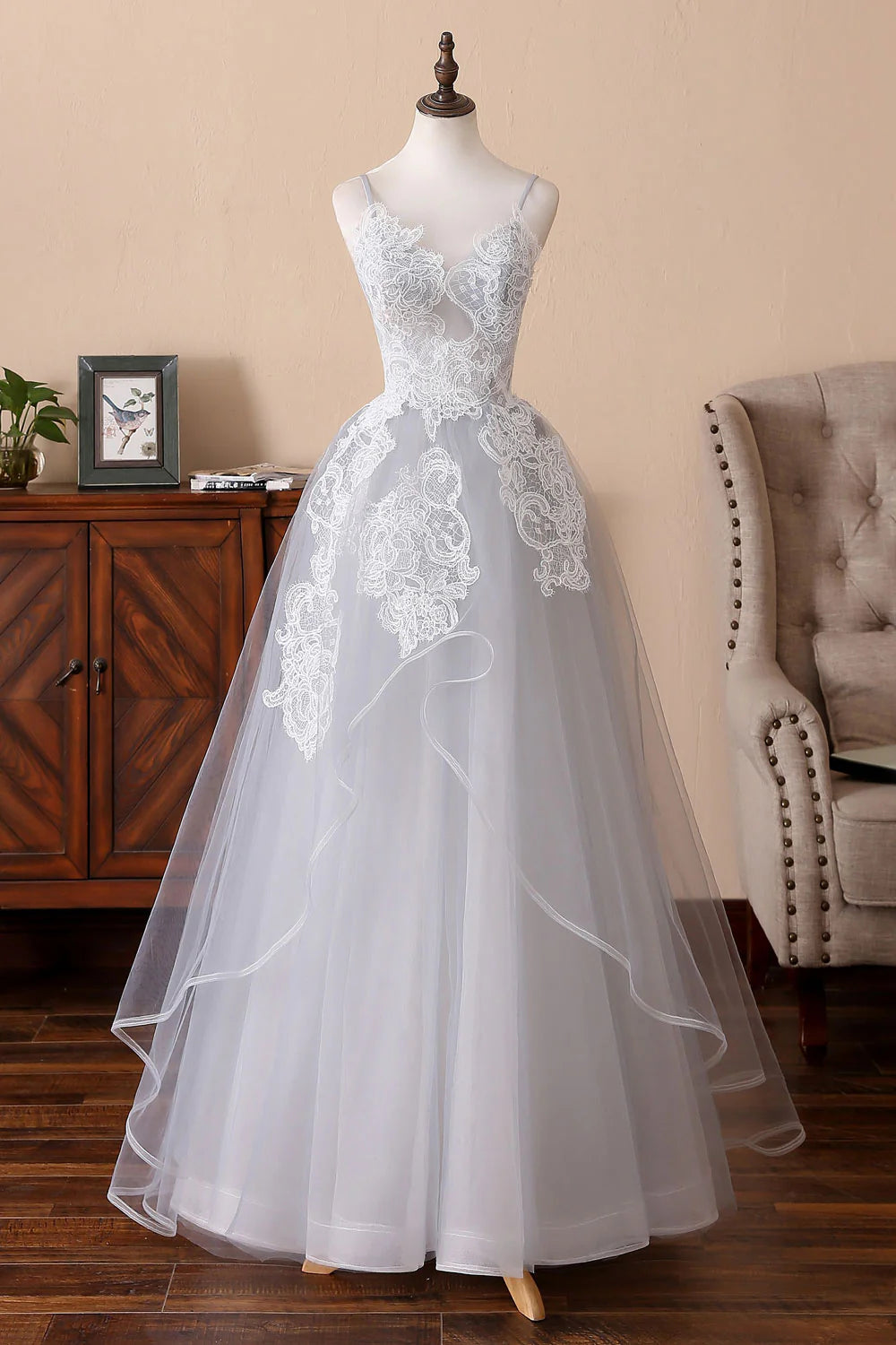 Woman posing in an elegant gray tulle lace long prom dress.