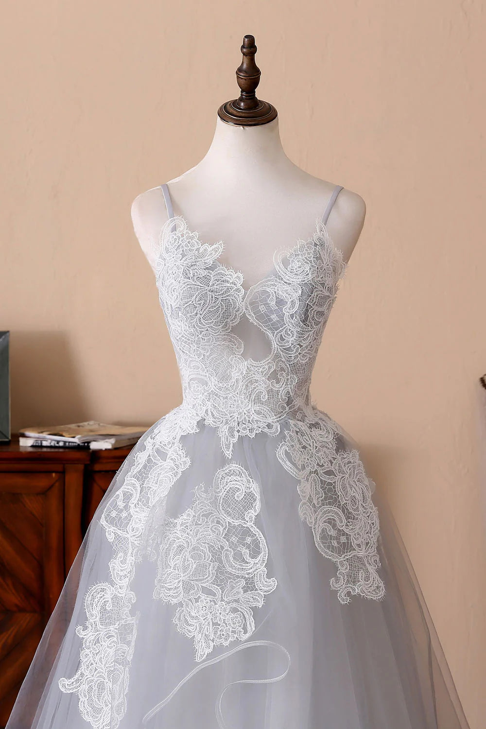 Side view of a woman in a gray evening gown with lace details.