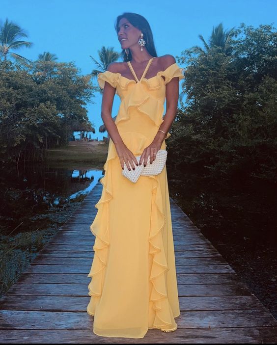 Woman wearing an elegant yellow halter A-line off-the-shoulder prom dress.