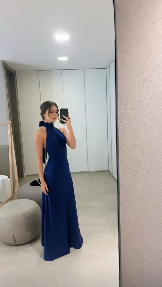 Woman wearing an elegant blue halter neck satin A-line long prom dress.