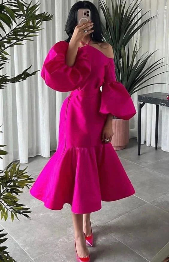 Elegant woman posing in a hot pink halter midi dress with puff sleeves and a belt.