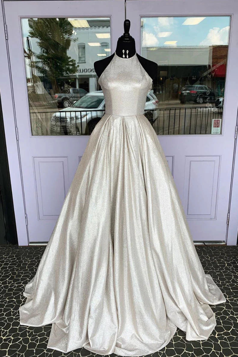 Woman wearing an elegant gray A-line long prom dress with a high neckline.