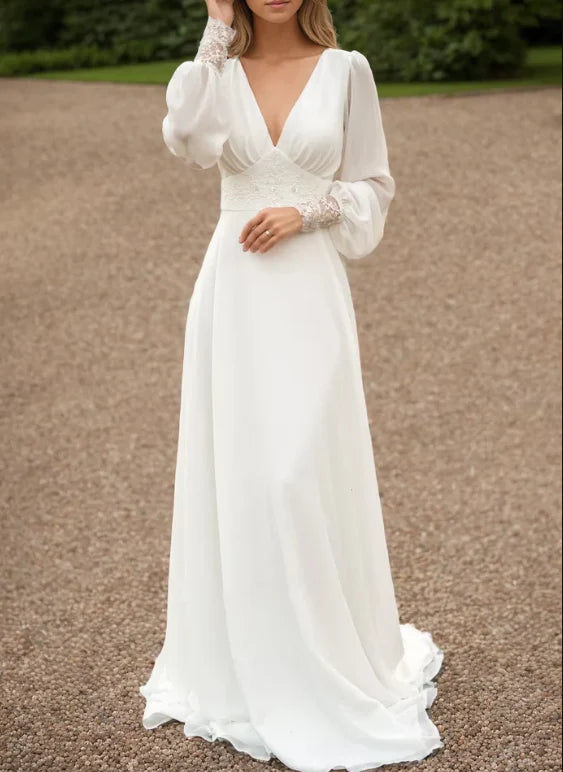 Side profile of the ivory long-sleeve wedding gown with its elegant train.
