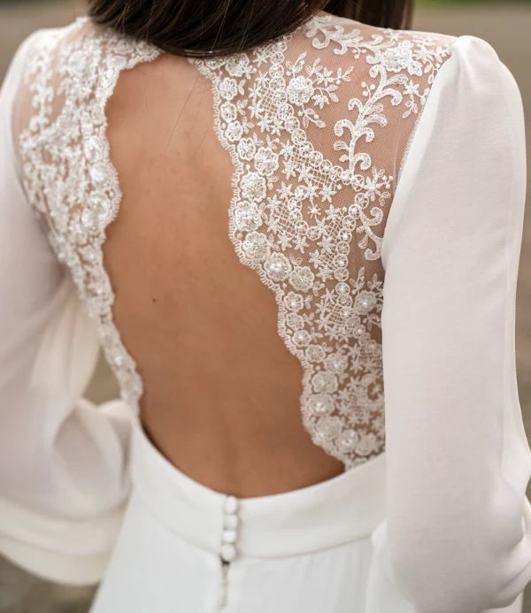 Close-up of the intricate lace bodice and long sleeves of the ivory bridal dress.