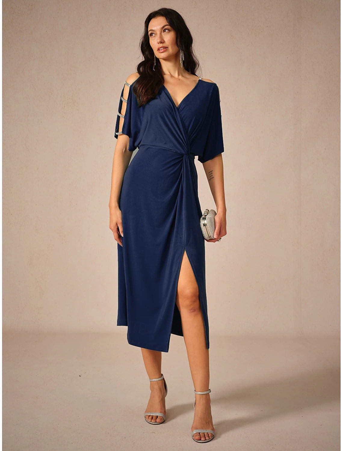 Woman wearing an elegant navy blue knit midi dress with a V-neck and short sleeves.