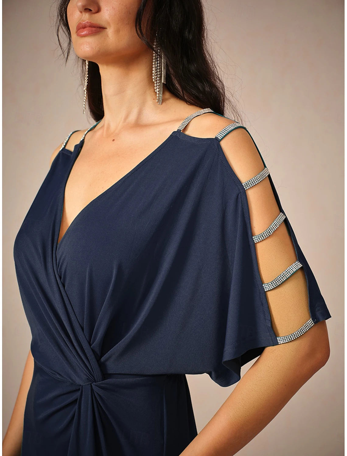 Woman posing in a stylish navy blue knit midi dress, showing the side profile.