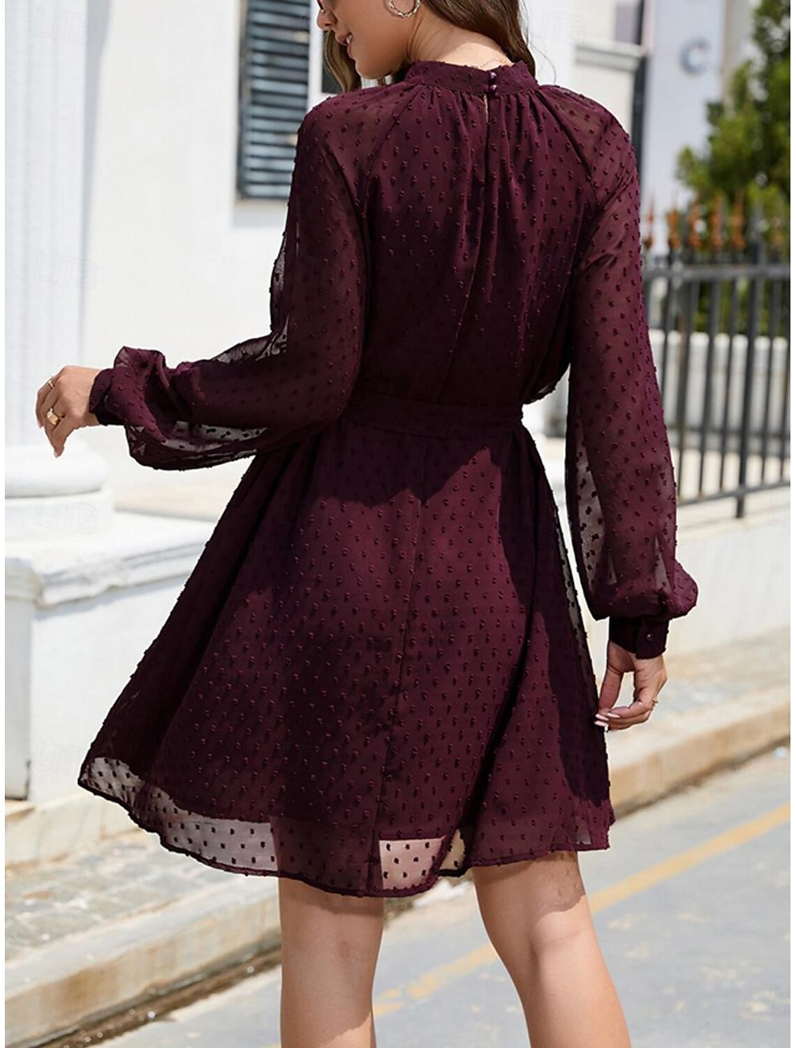 Back view of the model in the elegant chiffon mini dress, highlighting the crew neck.