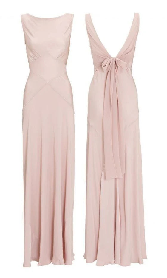 Woman wearing an elegant pink chiffon long prom dress with a lace-up V-back.