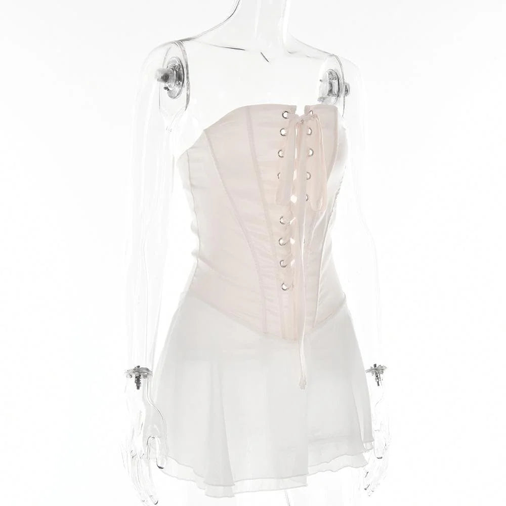 Close-up of the strapless corset bodice and ruffled fabric on the light pink mini dress.