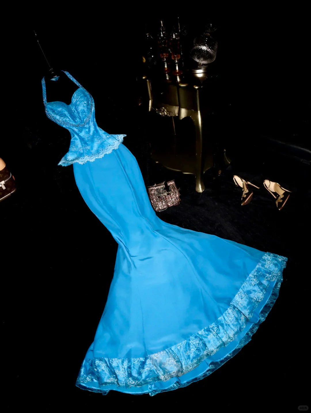 Woman wearing a blue mermaid halter dress with beads and sequins.