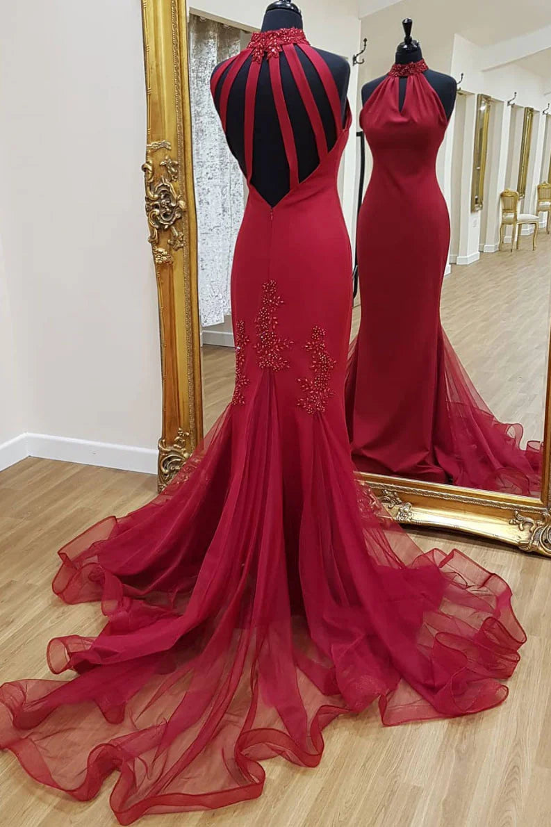 Woman wearing an elegant dark high-neck lace mermaid prom dress.