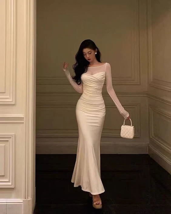 Woman wearing an elegant black mermaid long sleeve patchwork evening gown.