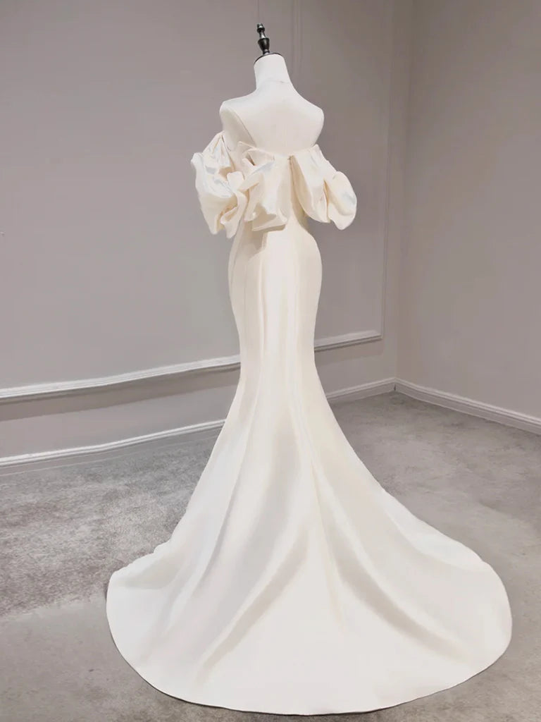Back view of a model wearing a light champagne mermaid off-shoulder evening dress.