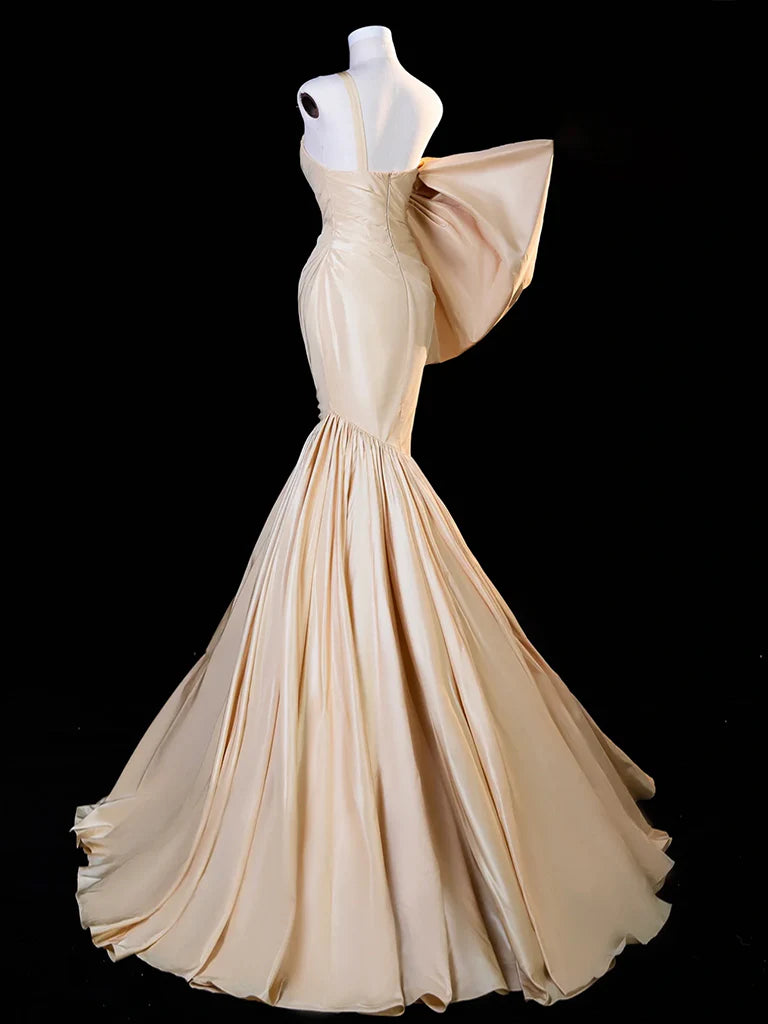 Back view of a woman in a champagne mermaid satin long formal dress.