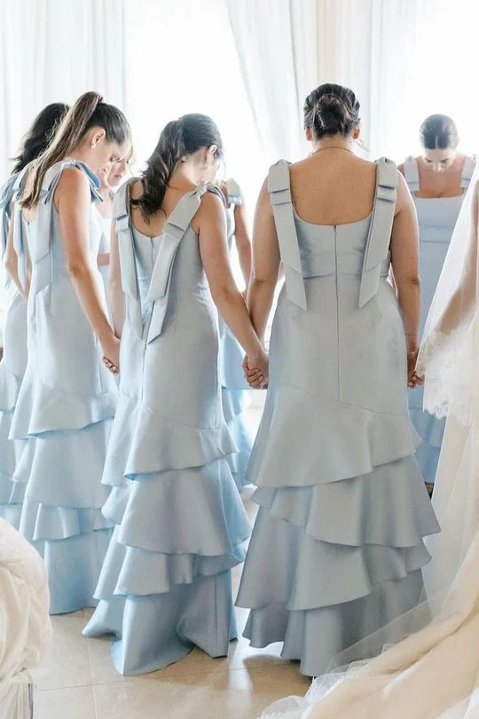 Close-up of the elegant light blue satin mermaid gown, showing tiered skirt and bow details.