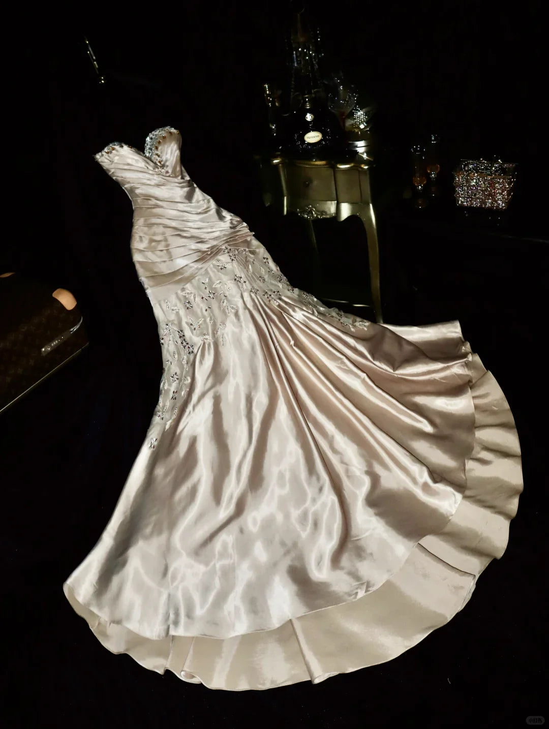 Woman wearing a champagne mermaid party dress with sweetheart neckline and beaded pleats.