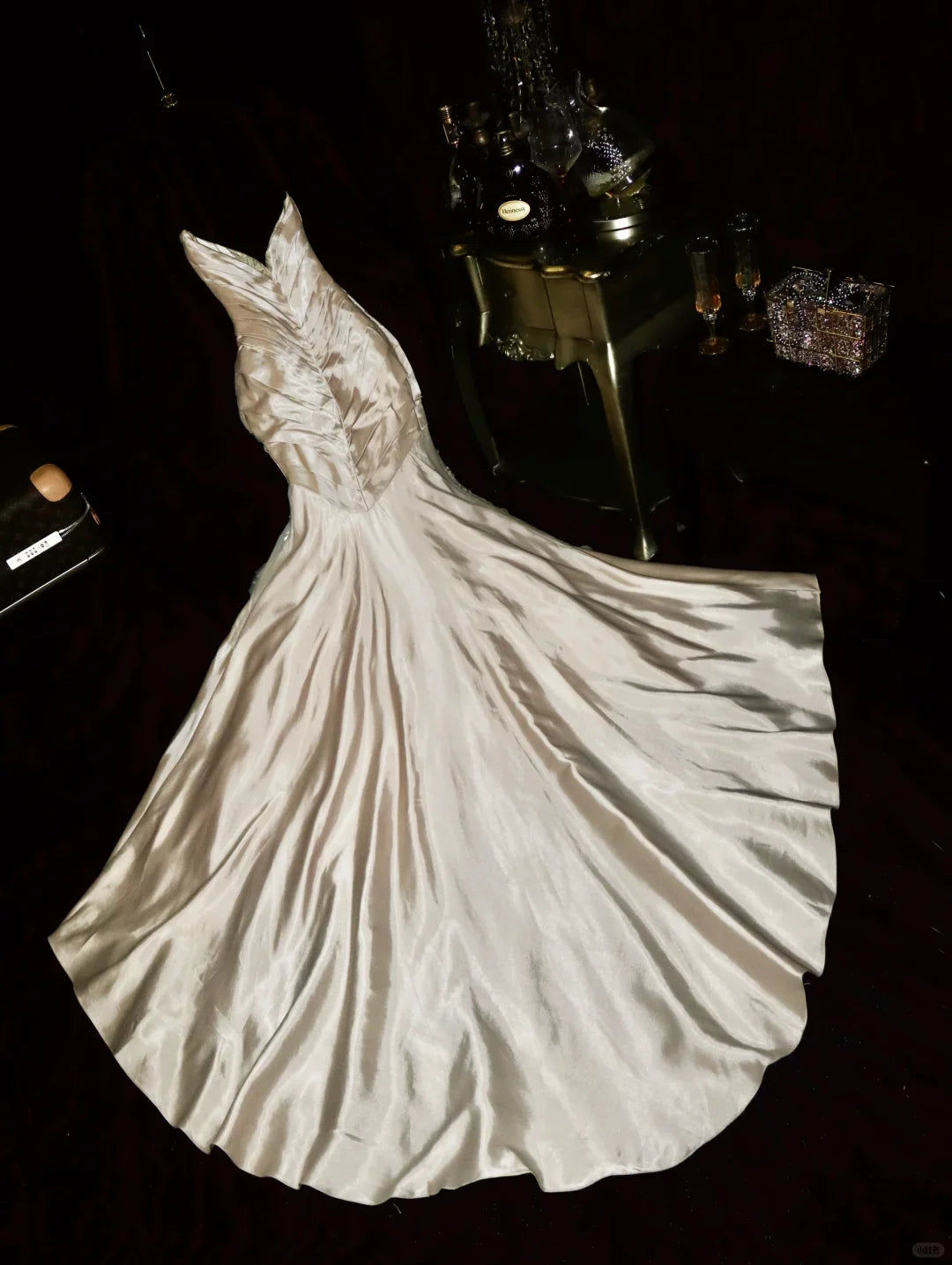 Woman posing in a champagne satin mermaid dress with sweetheart neck and beaded details.