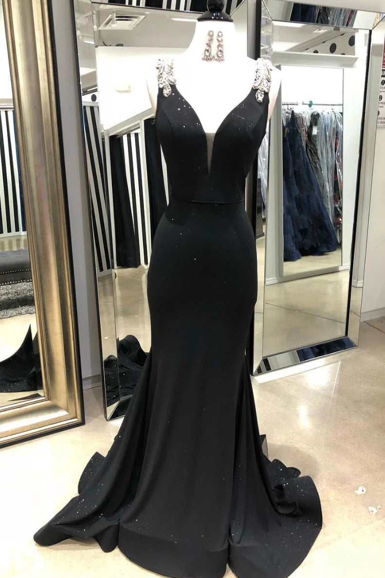 Woman wearing an elegant black V-neck mermaid long prom dress, posing gracefully.