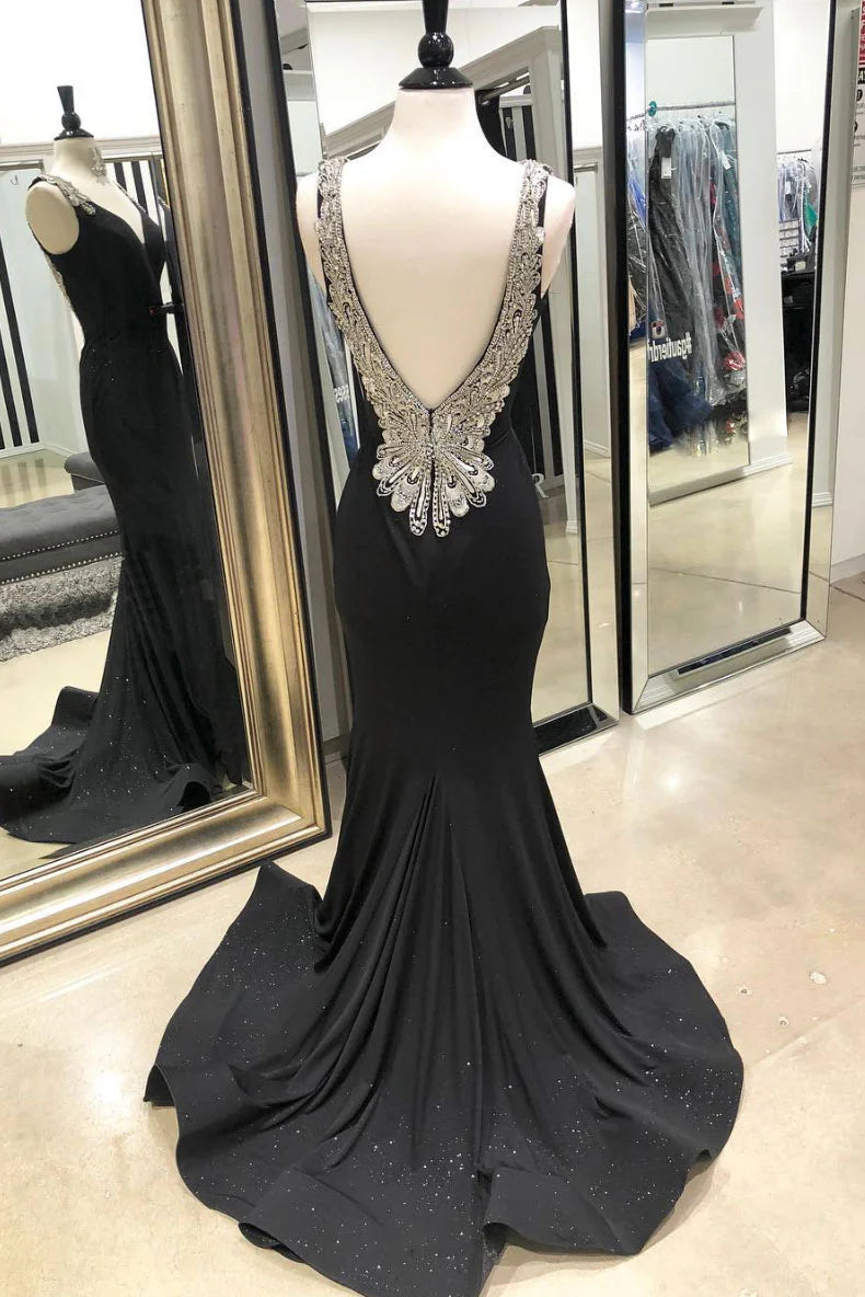 Back view of a woman in a black V-neck mermaid long prom dress, showing the train.