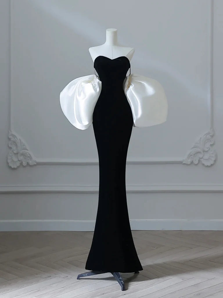 Model wearing a black velvet mermaid long prom dress, front view.