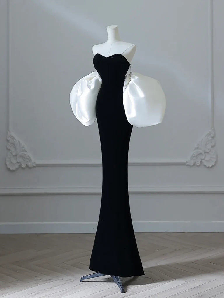 Model wearing a black velvet mermaid long prom dress, side view.